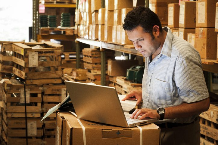 warehouse manager looking at laptop